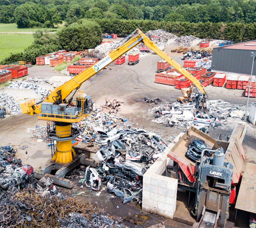 Une grue géante déplaçant des carcasses de voitures